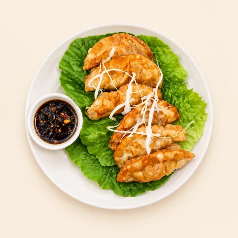 Six pan-fried pork dumplings with dipping sauce