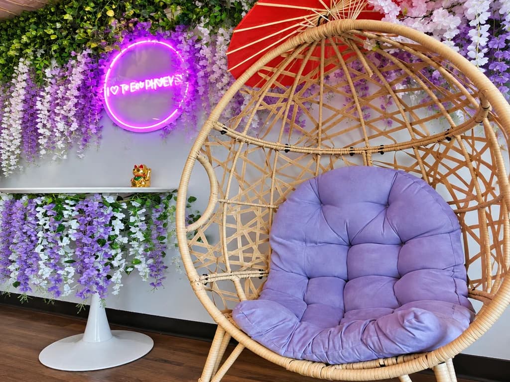 An egg chair beneath the neon heart sign inside Phoever