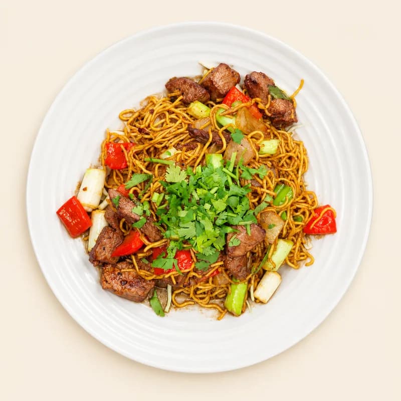Shaken beef with onion and bell pepper over pan-fried egg noodles